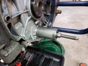 Engine housing with puller tool and drain pan
