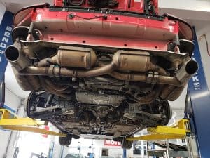 Underside of red car on hydraulic lift