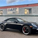 Black Porsche convertible parked outside Dart Auto dealership
