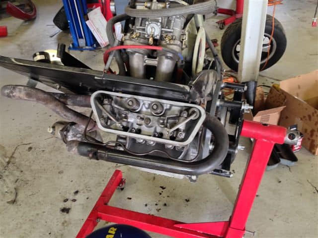 Car engine mounted on red engine stand