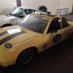 Yellow vintage Porsche race car in garage