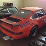 Orange vintage Porsche race car in garage