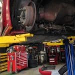 Car lifted on hydraulic lift in auto shop
