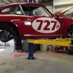Red vintage race car on hydraulic lift