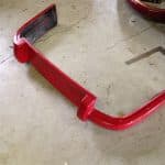 Red car bumper on garage floor