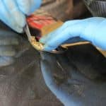 Gloved hands repairing a smartphone with tools