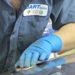 Auto technician polishing car surface with buffer