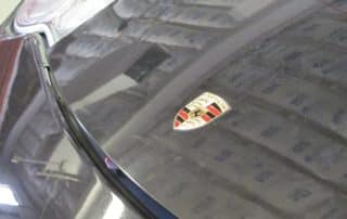 Porsche emblem on black car hood