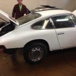 White classic car in garage with open hood