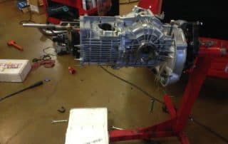 Car transmission mounted on red engine stand
