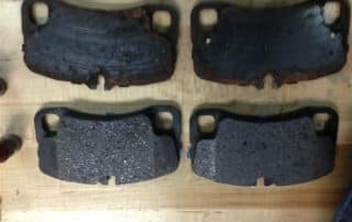 Worn and new brake pads on wooden surface