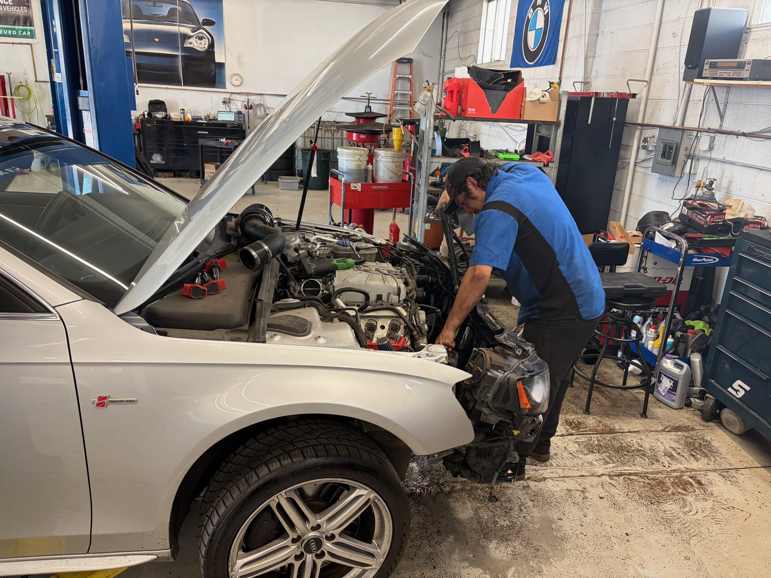 Mechanic repairing white car in auto shop