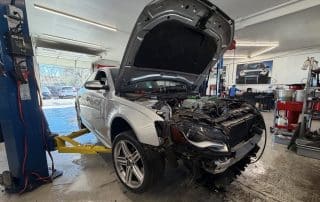 White Audi on lift with hood open