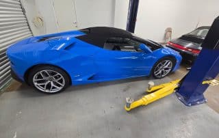 Blue Lamborghini convertible in auto repair garage