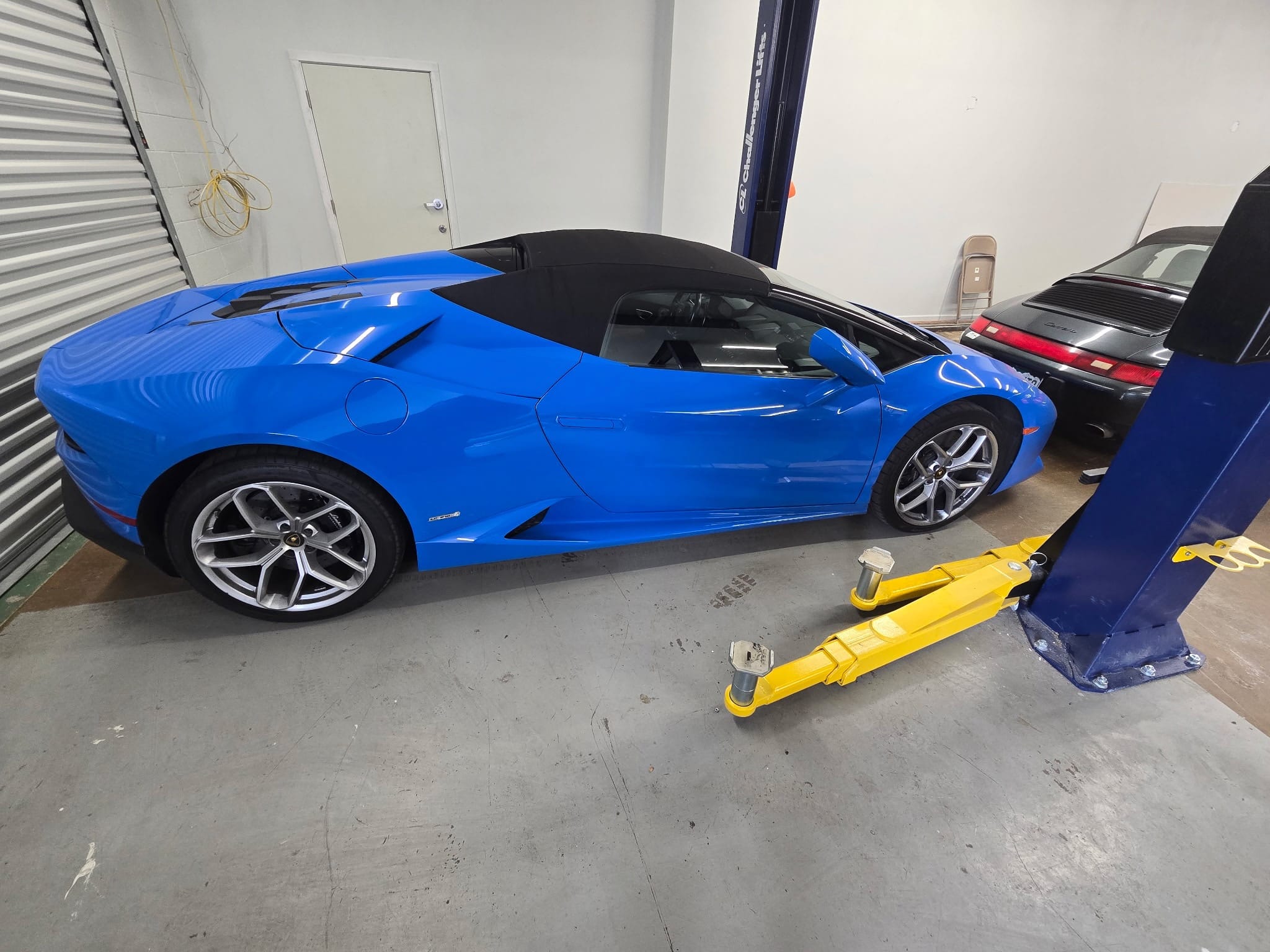 Blue Lamborghini convertible in auto repair garage