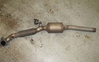 Used catalytic converter and exhaust pipe on floor