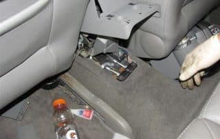 Car interior with seat removed and exposed bracket