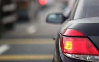 Car rear brake light illuminated on city street
