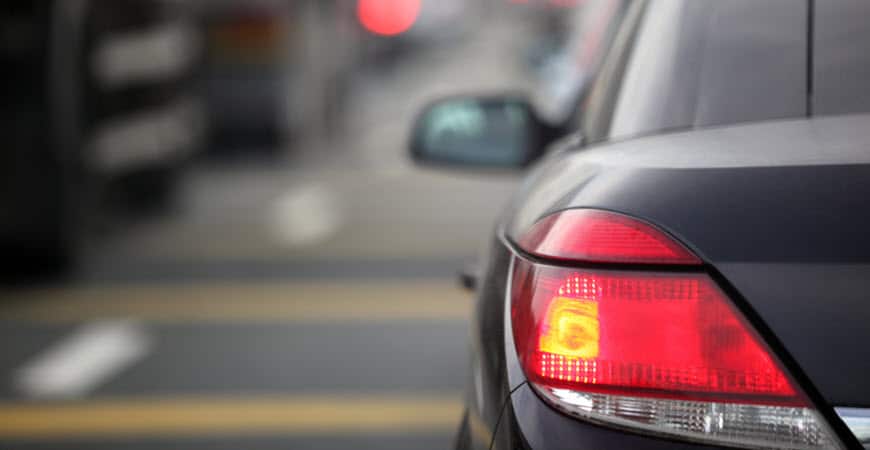 Car rear brake light illuminated on city street