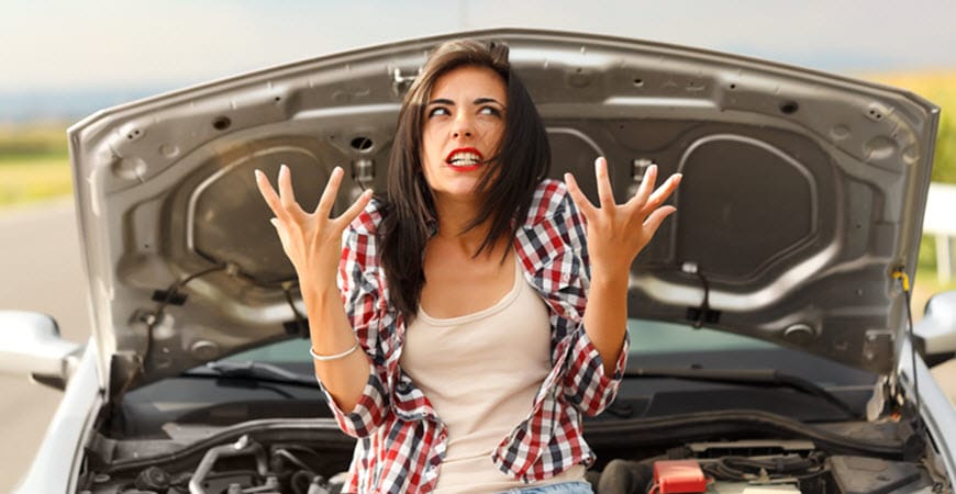 Frustrated woman standing by car with open hood