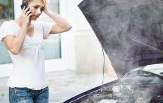 Woman calling for help beside smoking car