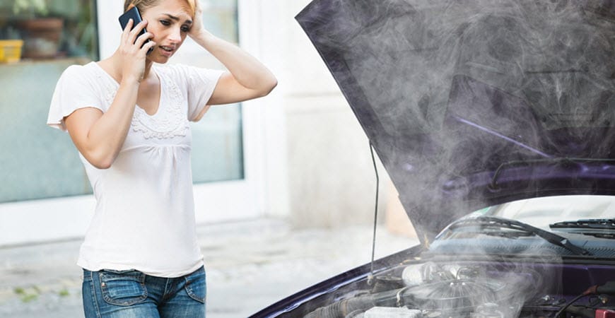 Woman calling for help beside smoking car