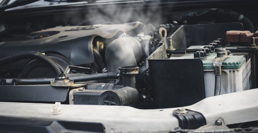 Car engine emitting steam under open hood