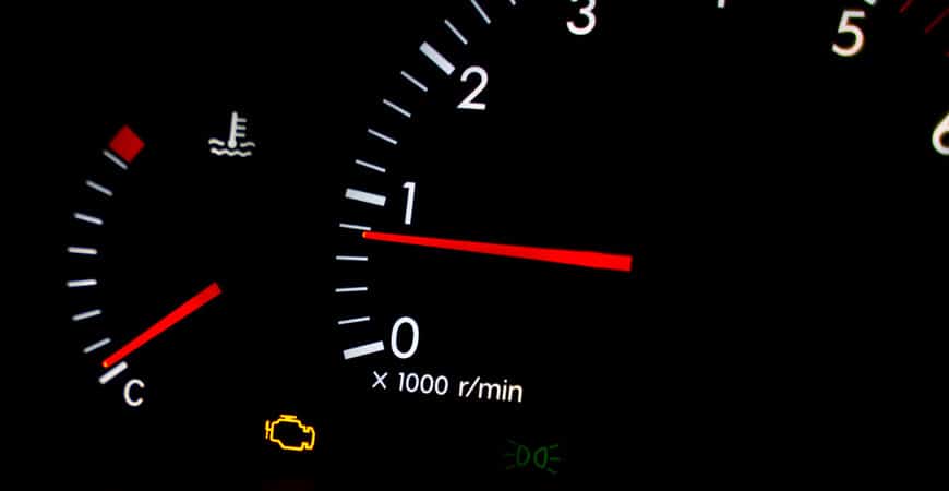 Car dashboard with illuminated check engine light