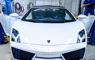 White Lamborghini in auto repair shop garage