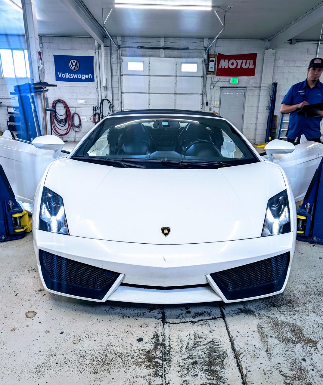 White Lamborghini in auto repair shop garage