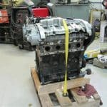Car engine strapped to pallet in workshop