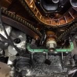 Close-up of engine timing chain and sludge buildup