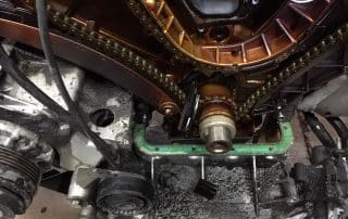 Close-up of engine timing chain and sludge buildup