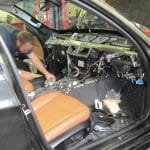 Mechanic repairing car interior with dashboard removed