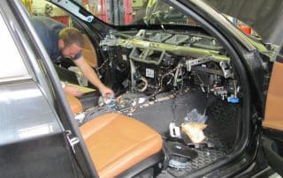 Mechanic repairing car dashboard interior wiring