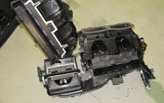 Disassembled car HVAC unit on workshop floor