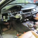 Car dashboard removed exposing wiring and steering column