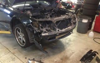 Car with front bumper removed in repair shop