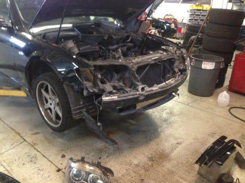 Car with front bumper removed in repair shop