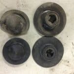 Four worn round metal mechanical parts on surface