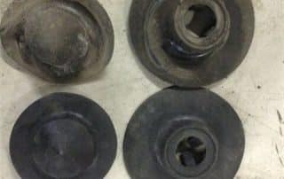 Four worn round metal mechanical parts on surface