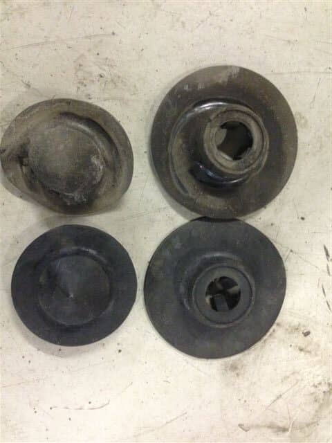Four worn round metal mechanical parts on surface