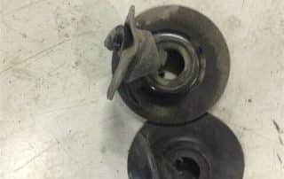 Two metal pump impellers on workbench