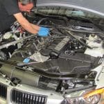 Mechanic working on BMW engine under hood