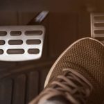 Foot pressing car pedal inside vehicle
