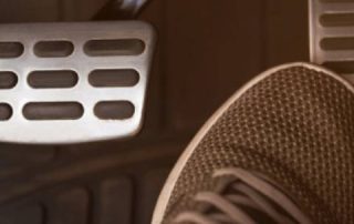 Foot pressing car pedal inside vehicle