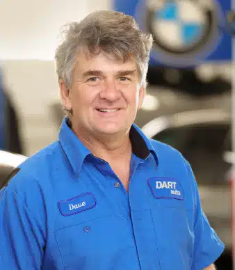 Auto mechanic in blue uniform smiling indoors