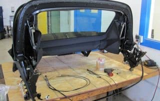 Convertible car top frame on workshop bench