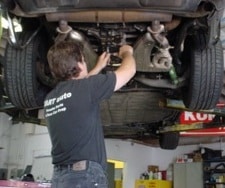 Mechanic repairing car under vehicle lift