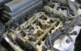 Exposed car engine with visible camshafts and timing chain